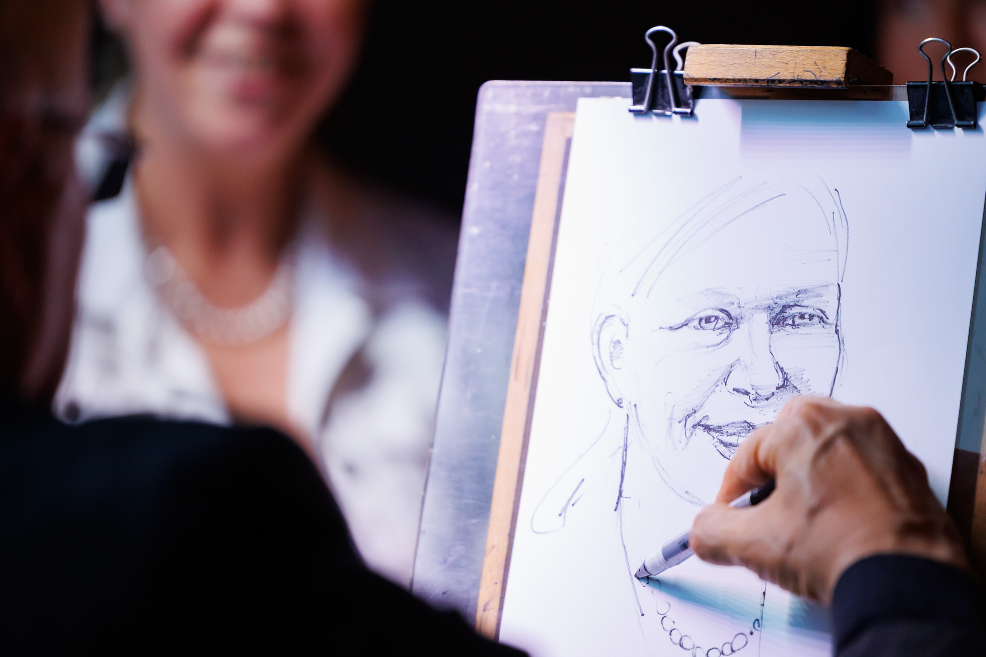 Karikatuurikunstnik peol külalisi joonistamas